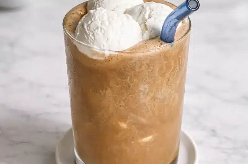 Banana Coffee Drinks served in a tall glass with a creamy iced coffee base topped with vanilla ice cream and a blue straw